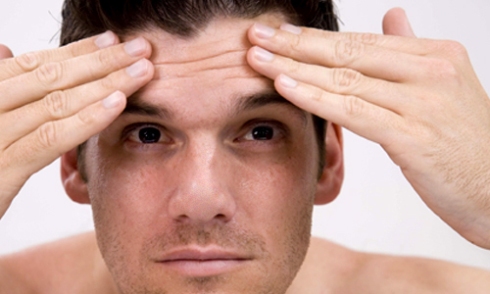 how to stop worrying man smoothing forehead wrinkles